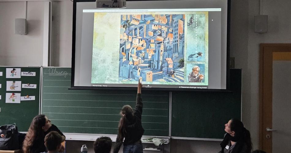 KInder schauen sich in der Klasse Bild auf der Leinwand an